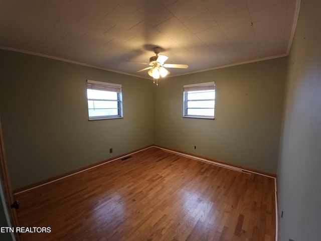 empty room featuring ceiling fan, ornamental molding, plenty of natural light, and light hardwood / wood-style flooring