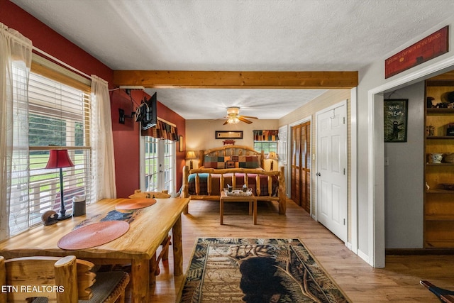 dining room featuring light hardwood / wood-style flooring, ceiling fan, a textured ceiling, french doors, and beamed ceiling