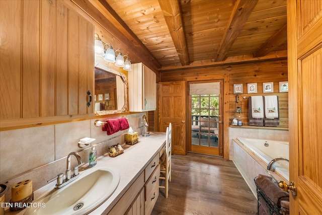 bathroom featuring wood ceiling, vanity, a relaxing tiled tub, beam ceiling, and hardwood / wood-style floors