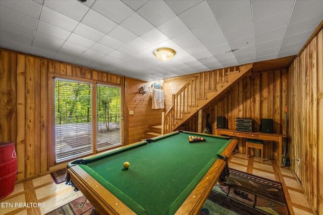 game room featuring light tile patterned floors, wooden walls, and billiards