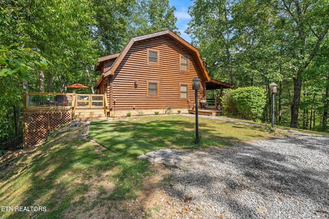 view of side of home featuring a wooden deck and a yard