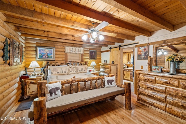 bedroom featuring light hardwood / wood-style flooring, beam ceiling, log walls, wooden ceiling, and a barn door