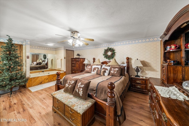 bedroom with ceiling fan, a textured ceiling, and light wood-type flooring