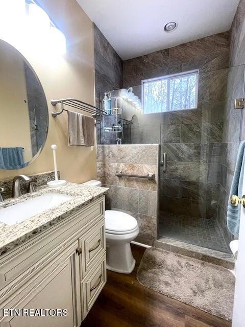 bathroom with vanity, hardwood / wood-style flooring, an enclosed shower, and toilet