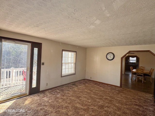 interior space with dark colored carpet and a textured ceiling