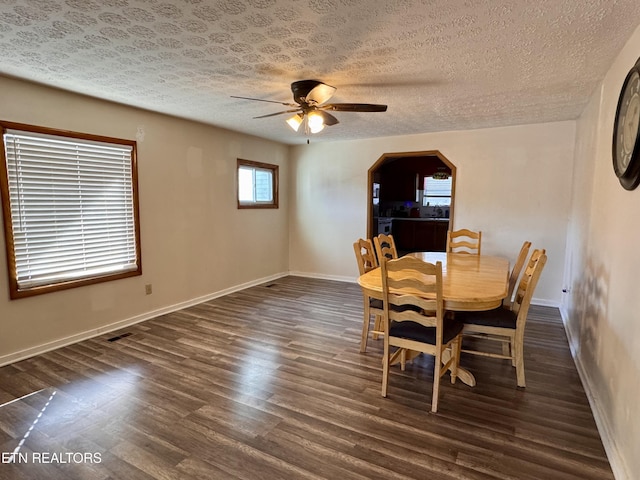 unfurnished dining area featuring dark hardwood / wood-style floors, a textured ceiling, and ceiling fan