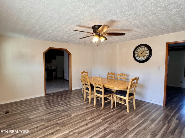 dining room with ceiling fan, a textured ceiling, and dark hardwood / wood-style flooring