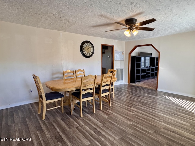 dining area with ceiling fan, dark hardwood / wood-style flooring, and a textured ceiling