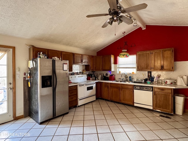 kitchen featuring pendant lighting, sink, white appliances, lofted ceiling with beams, and decorative backsplash