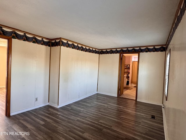 spare room with crown molding and dark hardwood / wood-style floors