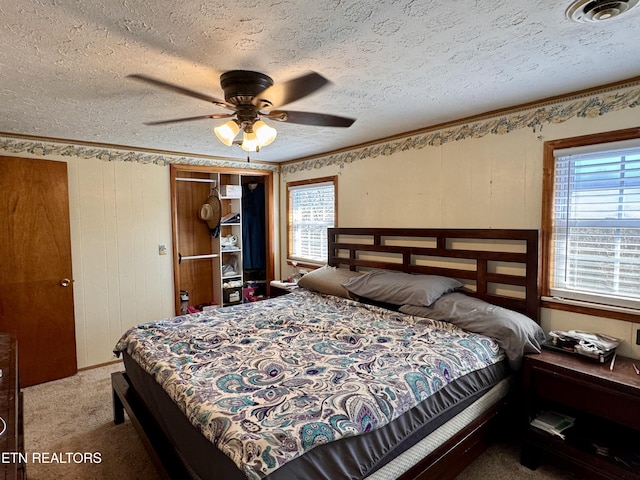 bedroom featuring ceiling fan, carpet floors, and a textured ceiling