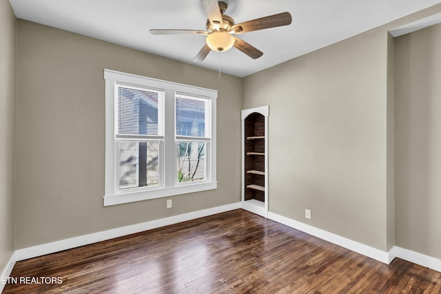 spare room with dark hardwood / wood-style flooring and ceiling fan