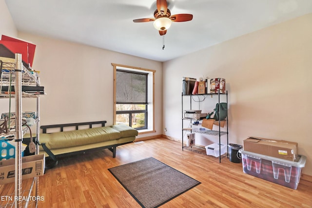 sitting room featuring wood-type flooring and ceiling fan