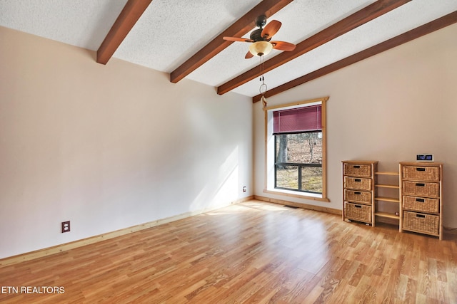 spare room with ceiling fan, light hardwood / wood-style flooring, lofted ceiling with beams, and a textured ceiling