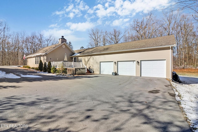 view of side of home with a garage and a deck