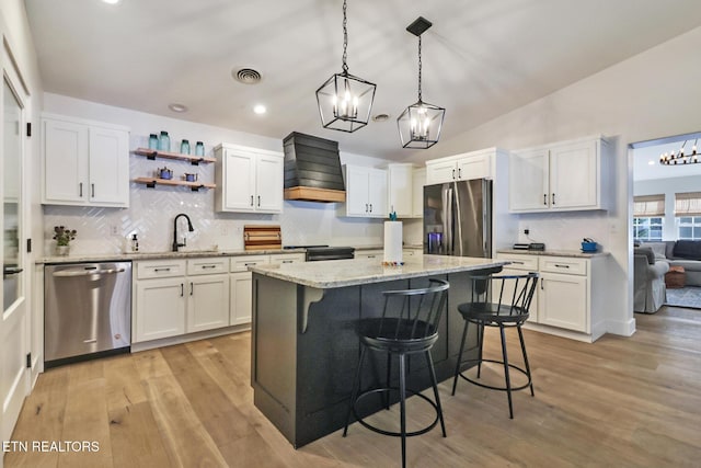 kitchen featuring stainless steel appliances, white cabinetry, and custom exhaust hood