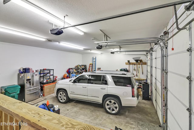 garage featuring a garage door opener and stainless steel fridge with ice dispenser