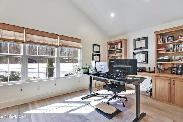 home office with lofted ceiling and light hardwood / wood-style flooring