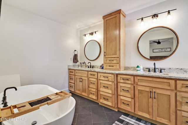 bathroom featuring tile patterned flooring, vanity, and a bathtub