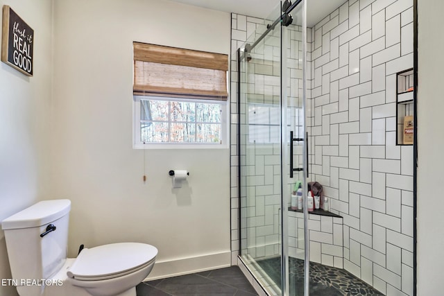 bathroom with a shower with door, tile patterned floors, and toilet