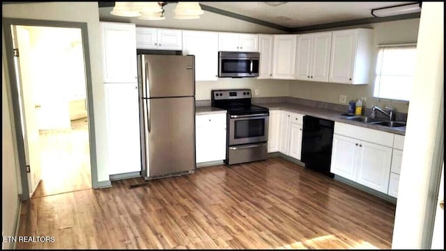 kitchen featuring sink, stainless steel appliances, white cabinetry, and hardwood / wood-style flooring