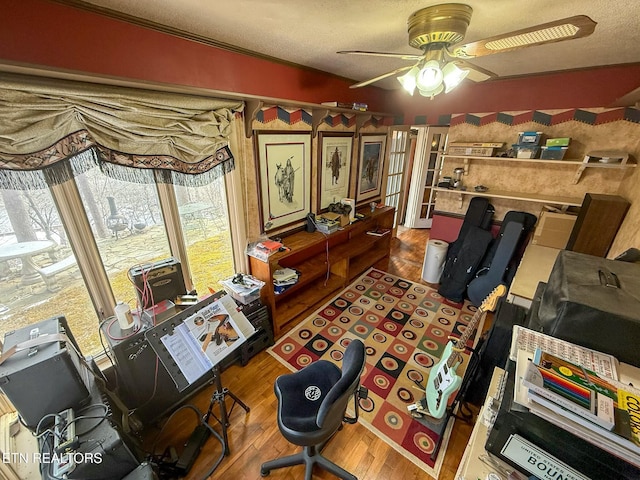 home office featuring ceiling fan, hardwood / wood-style floors, and a textured ceiling