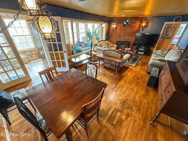 dining room featuring hardwood / wood-style flooring and brick wall