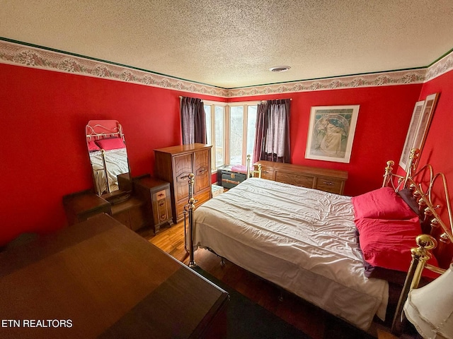 bedroom with wood-type flooring and a textured ceiling