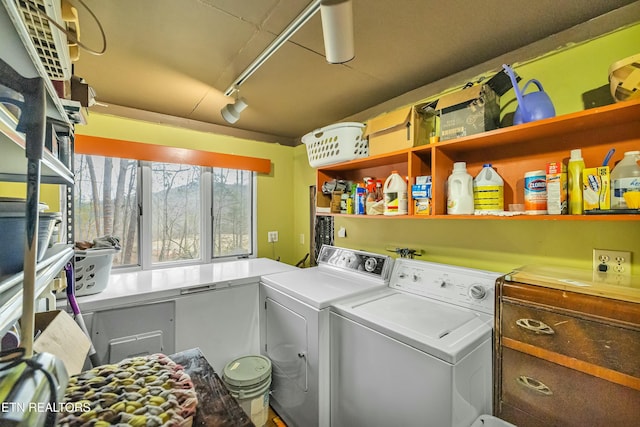 washroom featuring laundry area, rail lighting, and independent washer and dryer