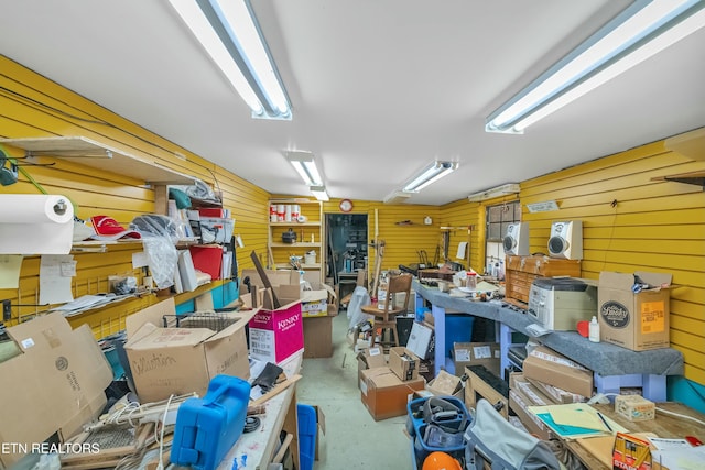 interior space featuring wooden walls, concrete floors, and a workshop area