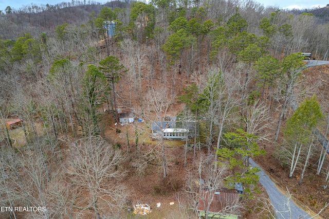 drone / aerial view featuring a wooded view