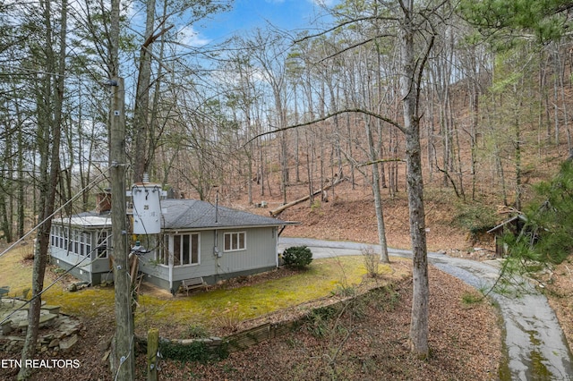 view of property exterior with roof with shingles