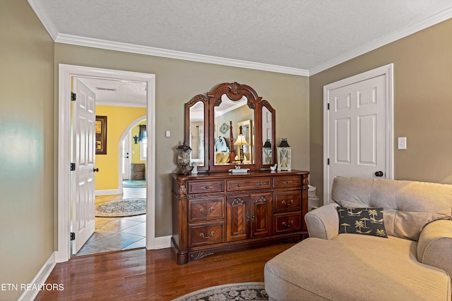 living area featuring ornamental molding, hardwood / wood-style floors, and a textured ceiling