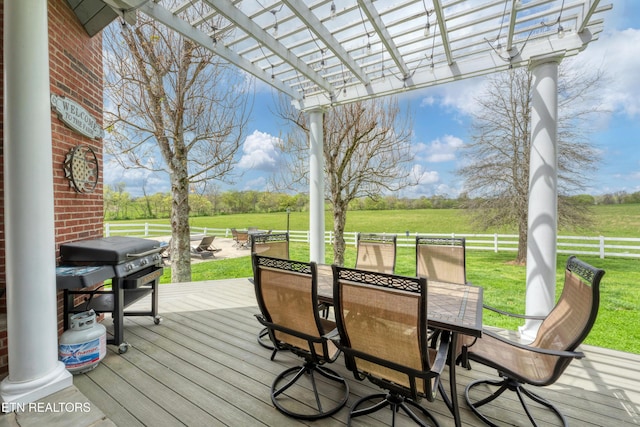 wooden terrace featuring a rural view, a grill, a pergola, and a yard