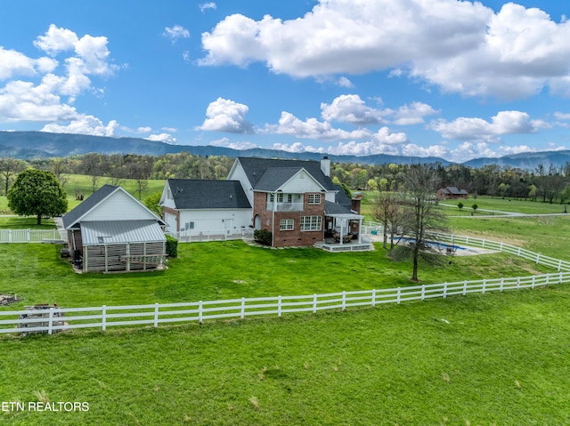 exterior space with a mountain view, a lawn, and a rural view