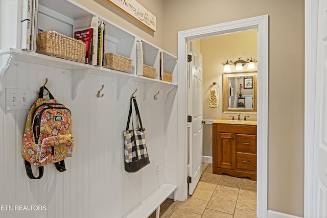 mudroom with light tile patterned flooring and sink