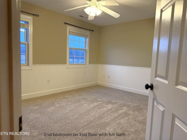 unfurnished room featuring ceiling fan and carpet floors