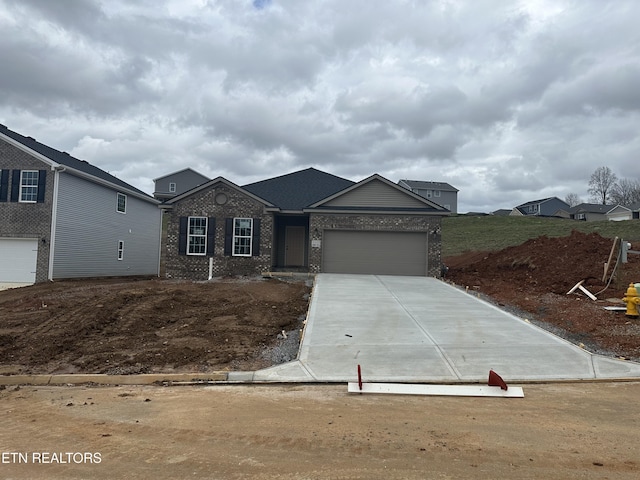 view of front of property with an attached garage, concrete driveway, and brick siding