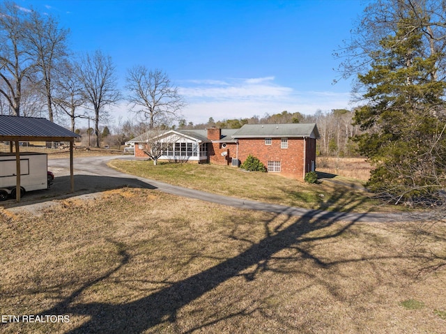 view of yard featuring a sunroom and a carport