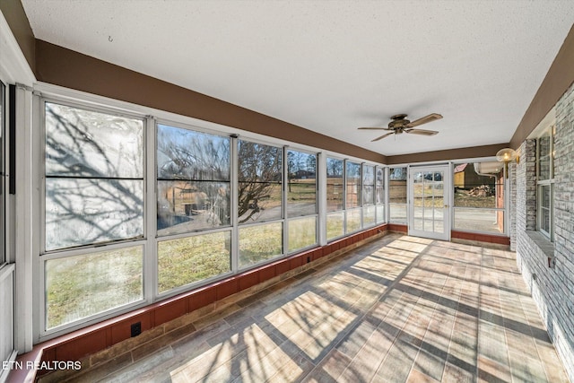 unfurnished sunroom with ceiling fan