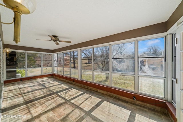 unfurnished sunroom with ceiling fan and a healthy amount of sunlight