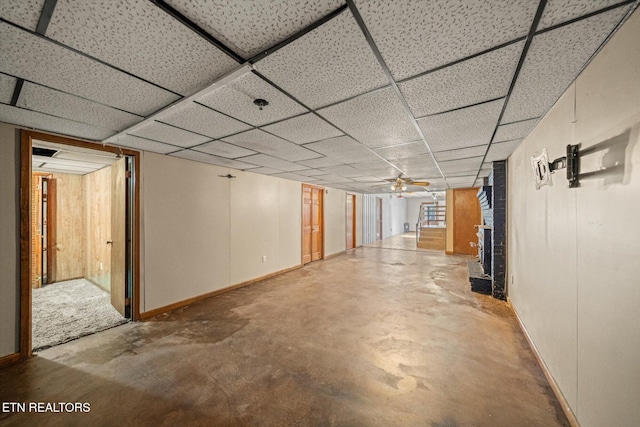 basement with a drop ceiling and ceiling fan