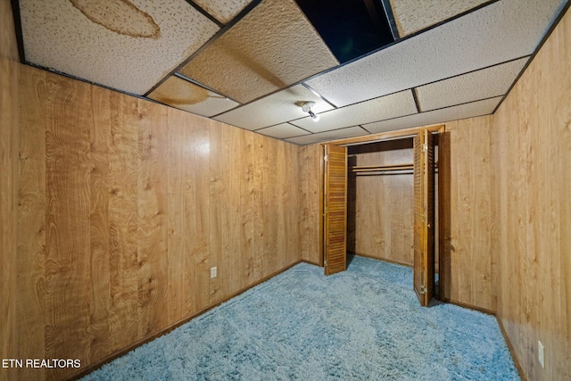 basement with light colored carpet and wooden walls