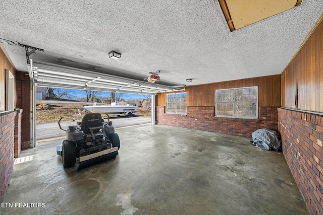 garage with a garage door opener and wooden walls