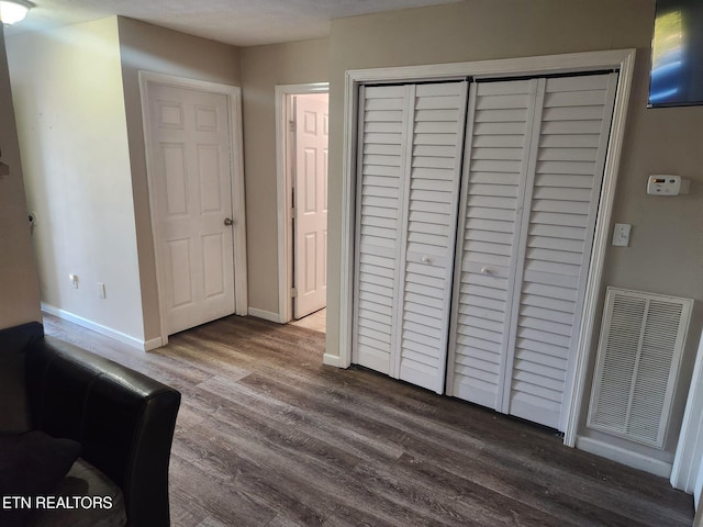 unfurnished bedroom featuring wood-type flooring and a closet