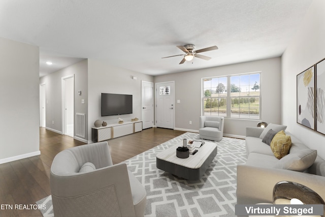 living area with ceiling fan, baseboards, visible vents, and wood finished floors