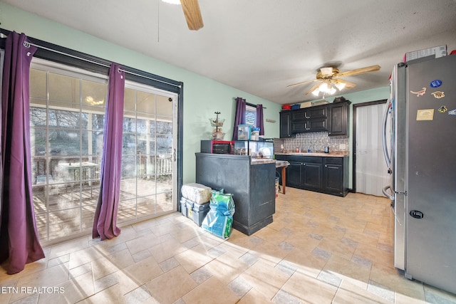 kitchen featuring ceiling fan, backsplash, and stainless steel refrigerator