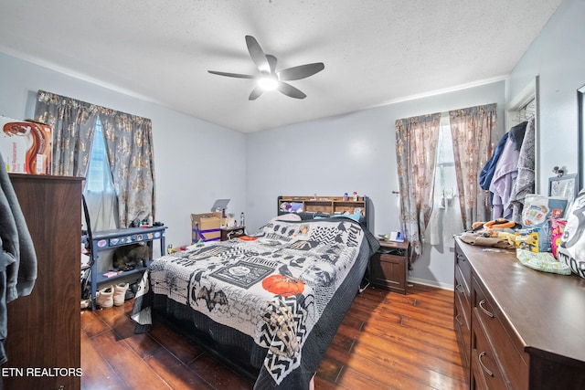 bedroom with multiple windows, ceiling fan, dark hardwood / wood-style floors, and a textured ceiling