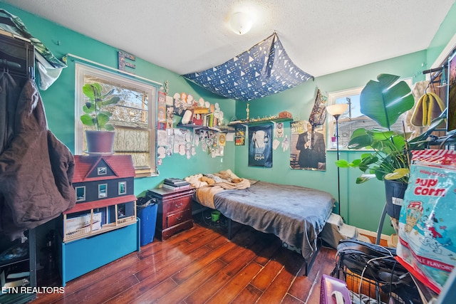 bedroom featuring dark hardwood / wood-style flooring and a textured ceiling