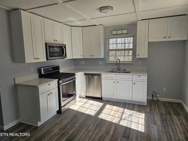 kitchen with sink, dark wood-type flooring, stainless steel appliances, and white cabinets